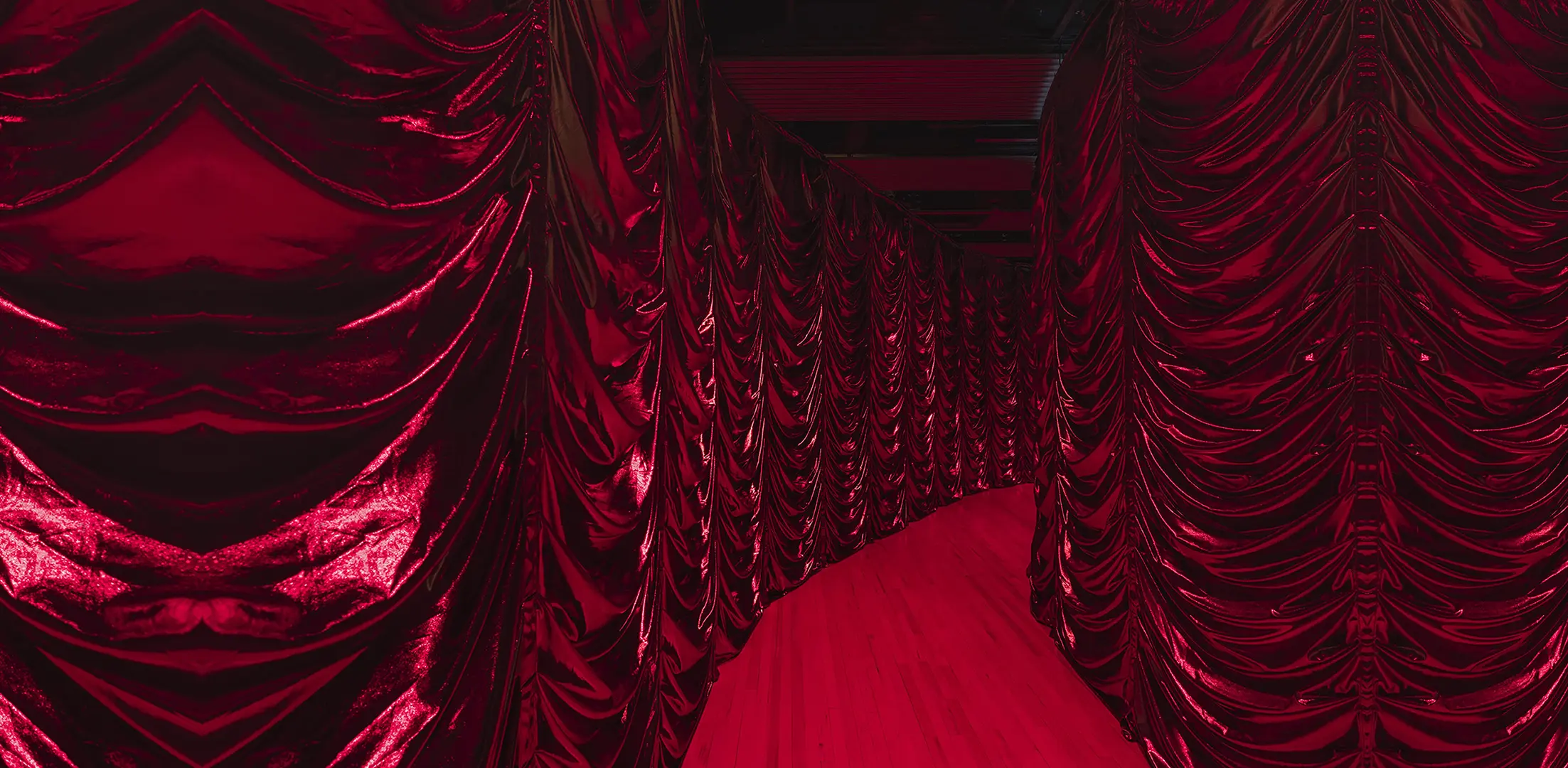 An image showing a red corridor. Down both sides are dark red drapes from J&C Joel.