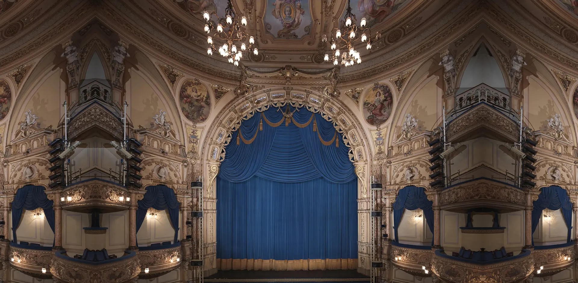 An image showing front of house theatre drapes. The drapes are dark blue in colour.